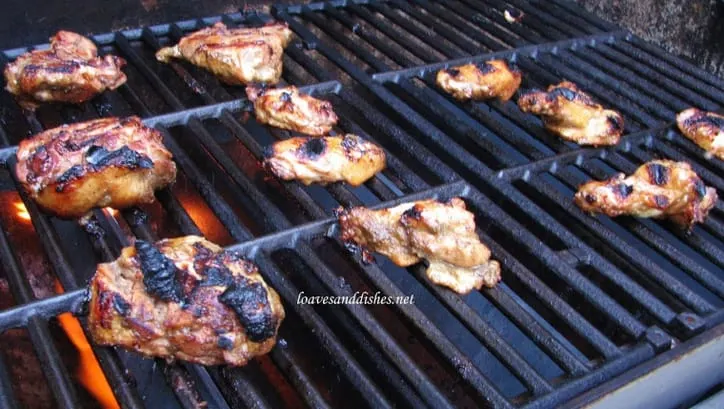 Chicken thighs on the grill with grill marks and flames