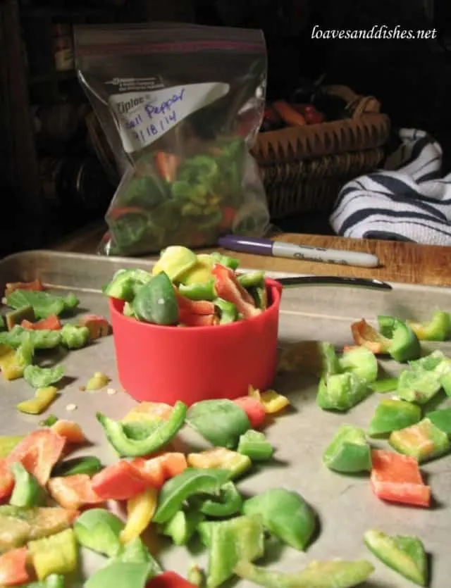 1/2 cup measure holding frozen bell pepper pieces