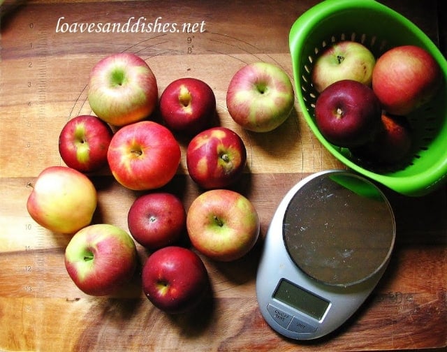 apples on a cutting board with scale and collander
