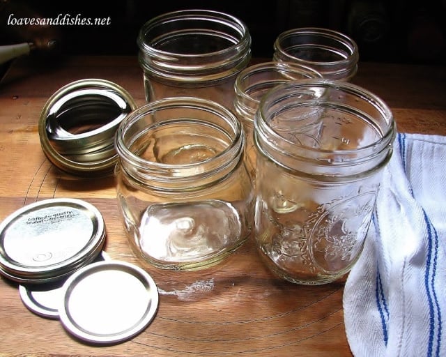 empty canning jars on a cutting board with a kitchen towel