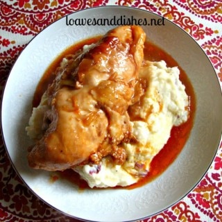 cooked chicken in sauce on top of mashed potatoes