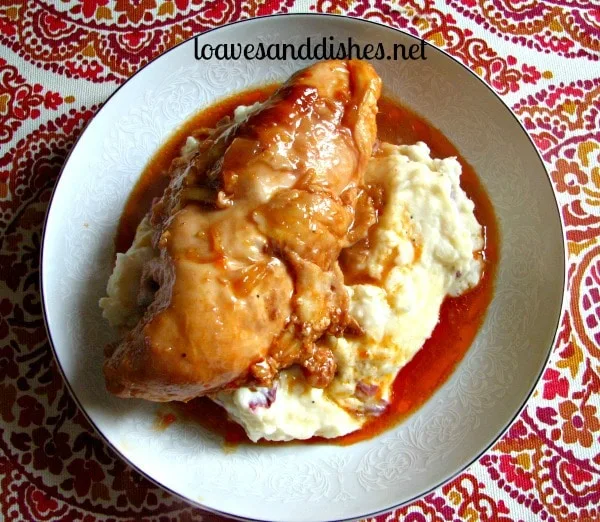 cooked chicken in sauce on top of mashed potatoes