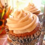 Pumpkin Spice Cupcakes with pumpkin cream cheese icing with flowers in background