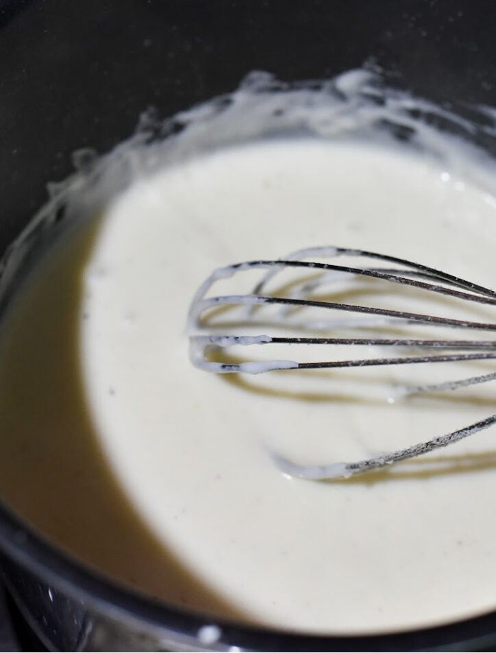 mushroom lasagna with white sauce with whisk