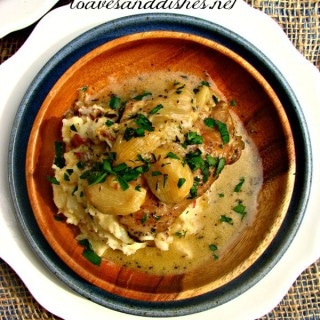 40 Garlic Chicken with mashed potatoes on a wooden plate with parsley sprinkled on top