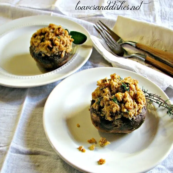 Quinoa and Asiago Stuffed Mushrooms on white plates with fresh thyme, and two forks