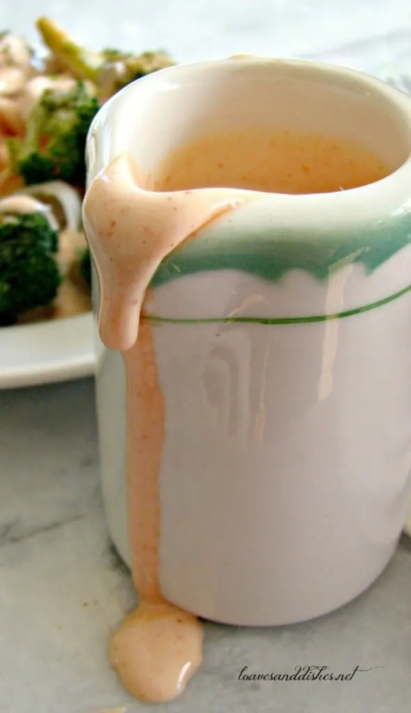yum yum sauce dripping down the edge of the white pitcher with green rim