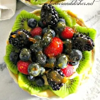 Mini Fruit Tart with glaze on a marble counter top
