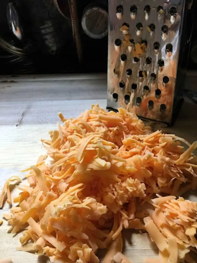 cheese grated with grater and cutting board