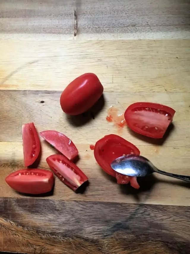 tomato halves with spoon and cutting board