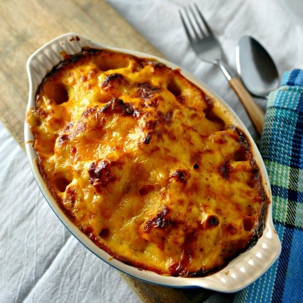 Melted cheese on cauliflower in a dish with a fork and spoon