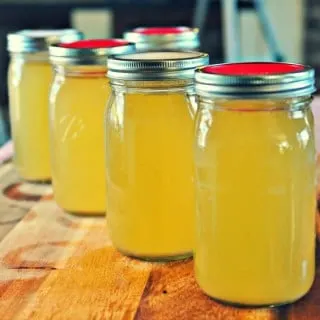 Easy Chicken Stock in quart jars with red and white lids