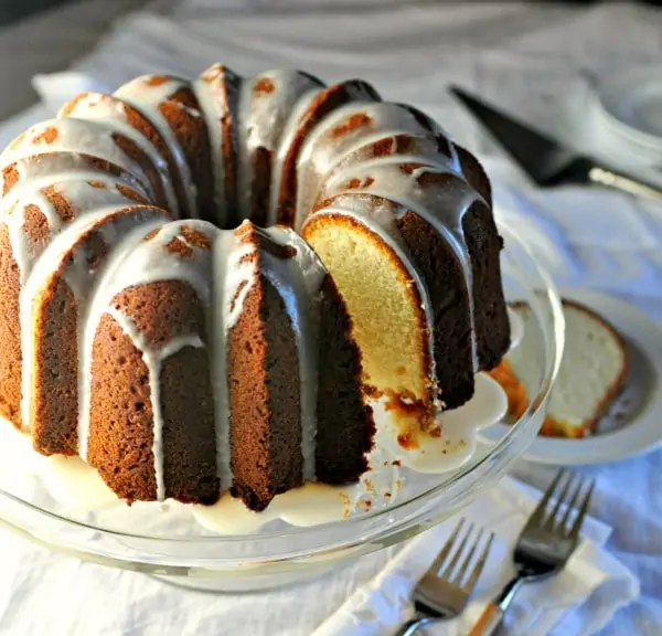 Easy Cream Cheese Pound Cake on a cake plate with a slice of cake in the background