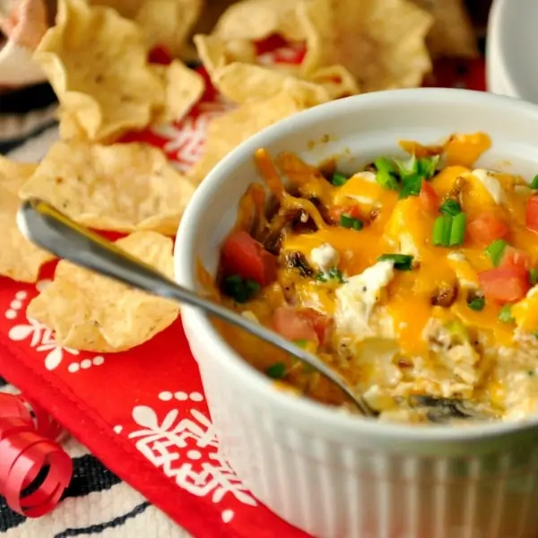 bowl of hot bacon dip with chips and spoon