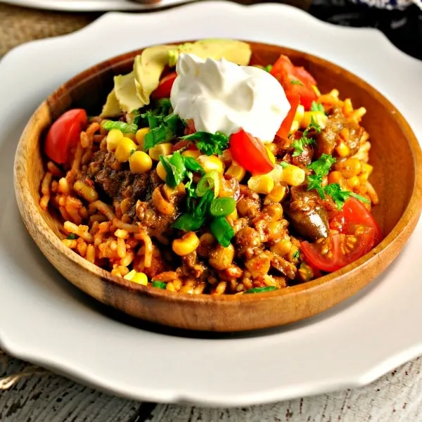 Southwest Corn Sauce with sour cream on top in a wooden bowl