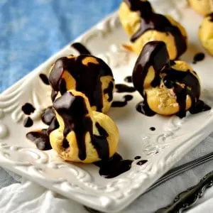 Cream Puff with espresso Cream Filling on a white plate with a blue table cloth