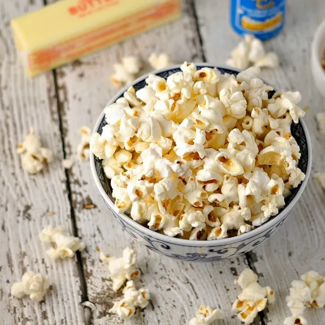 popcorn in bowl with butter and salt in the back ground