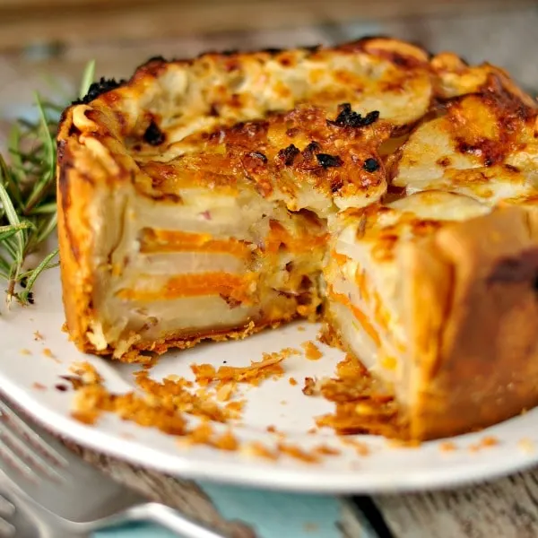 Root Vegetable Rosemary Gratin with a slice removed on a white plate