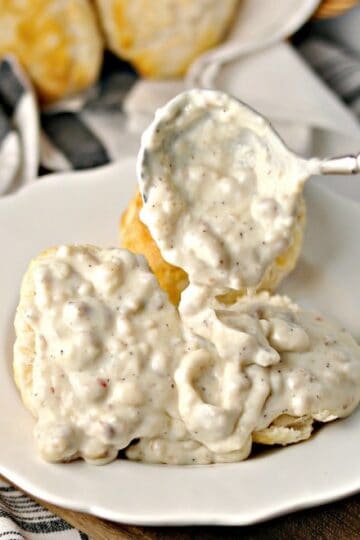 Sausage Gravy on biscuits on a white plate