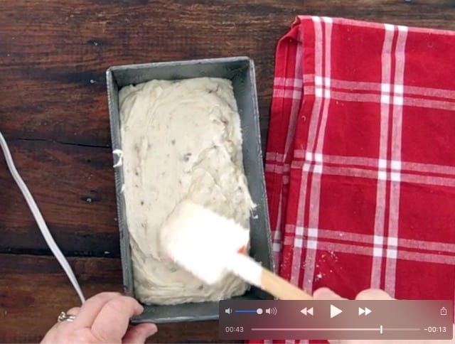 Spatula spreading the banana bread batter in the loaf pan