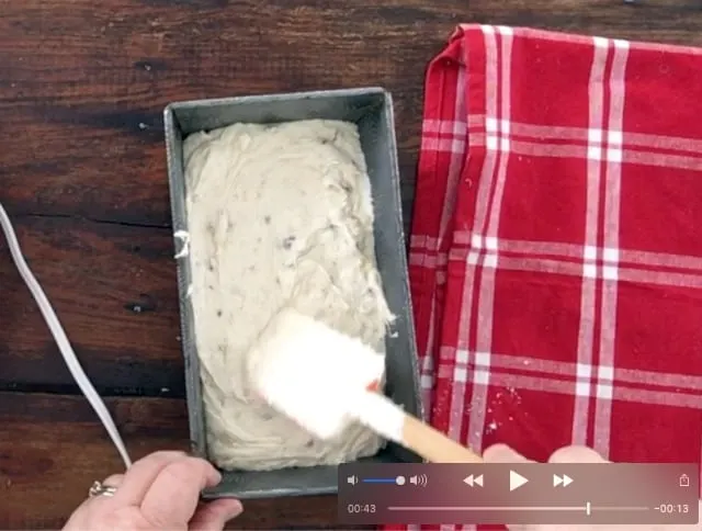 Spatula spreading the banana bread batter in the loaf pan