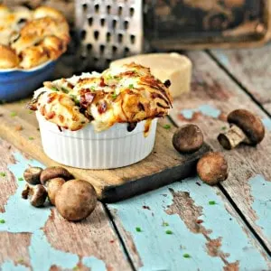 Mushroom (Bacon) Pull Apart Bread in a white dish with button mushrooms sprinkled around