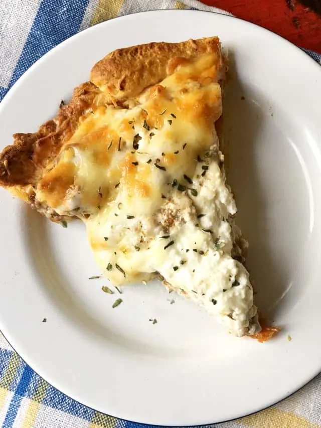 A slice of taco pie with melty cheese on a white plate