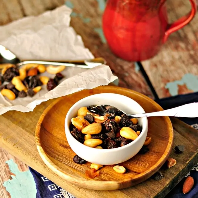 trail mix in a white bowl with spoon