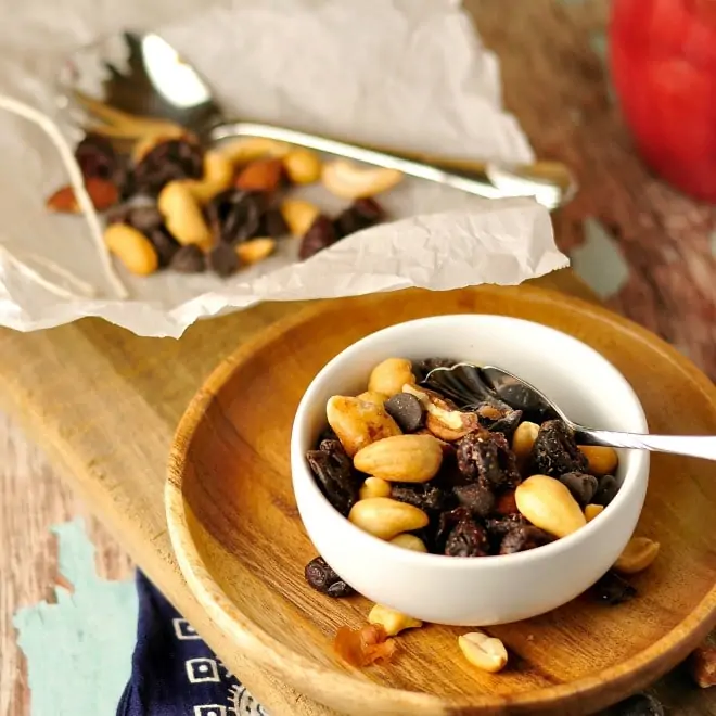 Granola with nuts, dried cherries and chocolate chips in a small white bowl