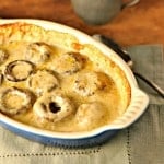 Mushroom caps in a cream sauce in a blue baking dish