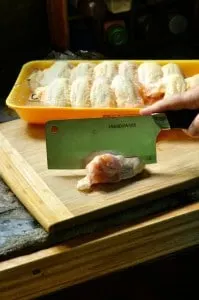 Raw chicken being cut up for chicken wings