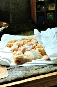 Uncooked chicken wings being dried off