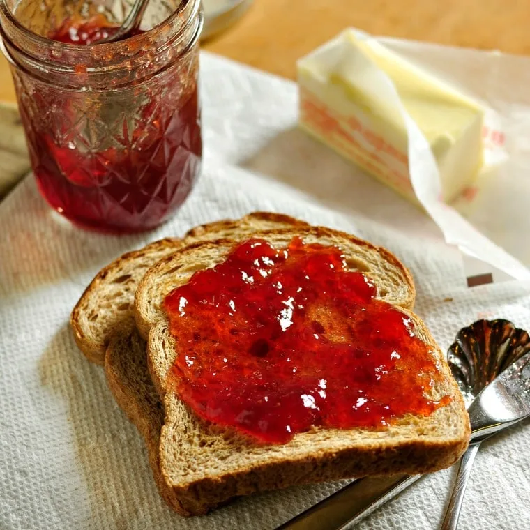 strawberry jam on toast with butter and spoon