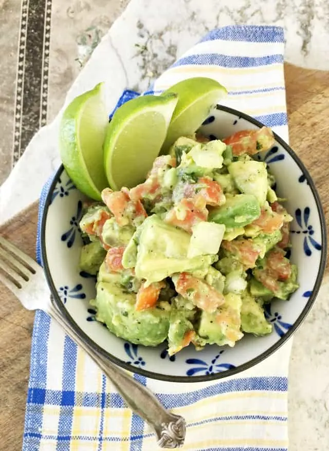 View from above of Guacamole Receta Facile in blue and white bowl, fork and blue napkin