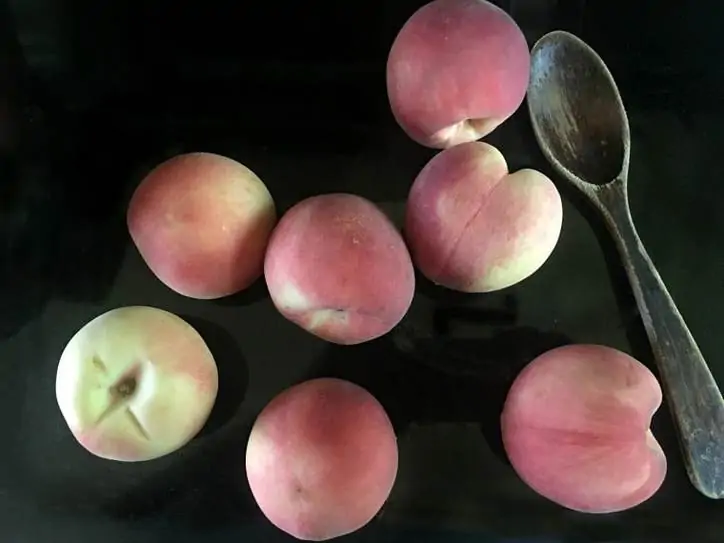 A photo of the whole peaches laying on my stove top Peach Pie with a Pecan Brown Sugar Crumble