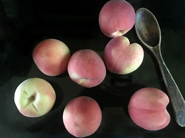 A photo of the whole peaches laying on my stove top Peach Pie with a Pecan Brown Sugar Crumble