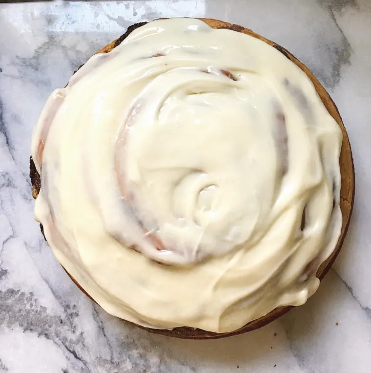 A photo from the top of cinnamon roll cake from scratch with the swirly frosting on top