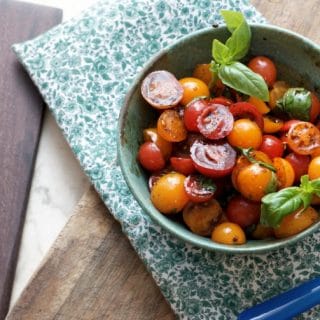 A photo from above of Summer Cherry Tomato Salad showing the green placemat and one piece of silverware