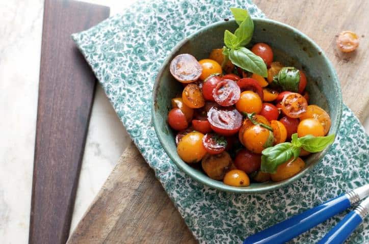 A photo from above of Summer Cherry Tomato Salad showing the green placemat and one piece of silverware