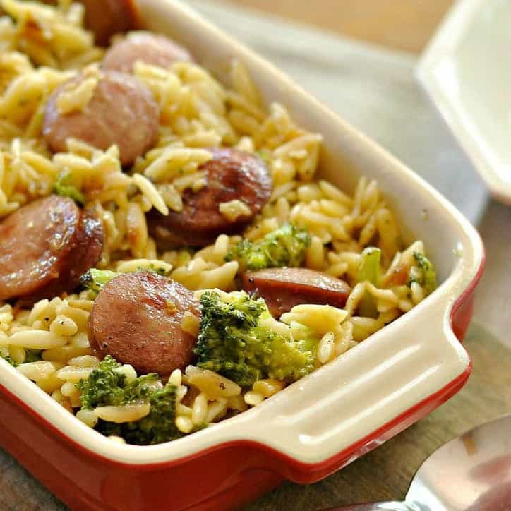 A photo of a casserole dish of Smoked Sausage and Cheesy Orzo @loavesanddishes.net