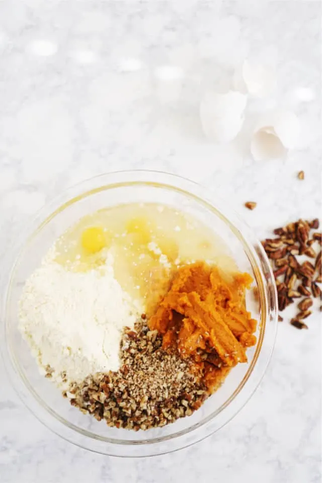 a bowl of the batter ingredients pumpkin and spices for the cake