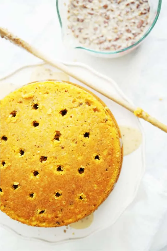 A top down view of the cakes with holes poked in the top and the wooden spoon handle