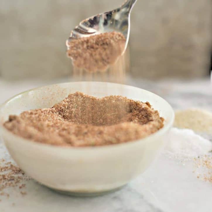 Spoon spilling spice rub into bowl