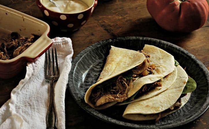 Three Easy Shredded Chicken Fajitas in the Crockpot on gray plate with fork
