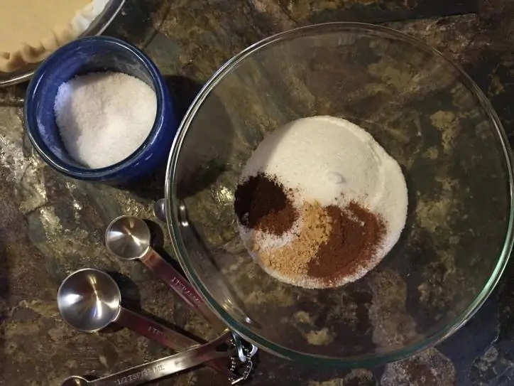 spices in a glass bowl with measuring spoons