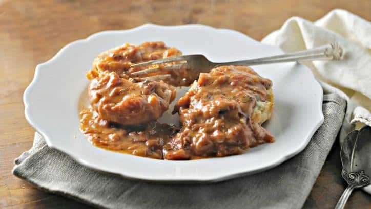 white plate with biscuit and tomato gravy