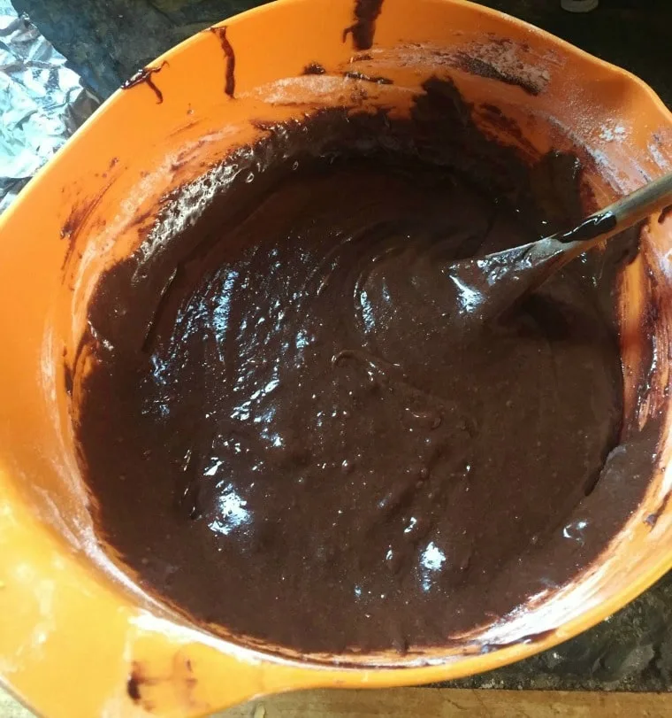 orange mixing bowl with brownie batter inside