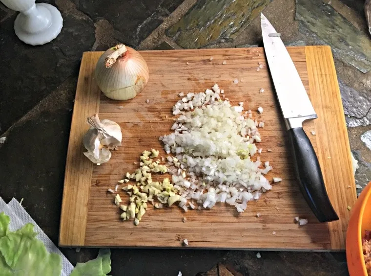 Cutting board and knife with chopped onion and garlic