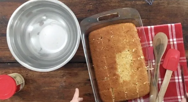 9x13 pan with cake mix baked cake and bowl