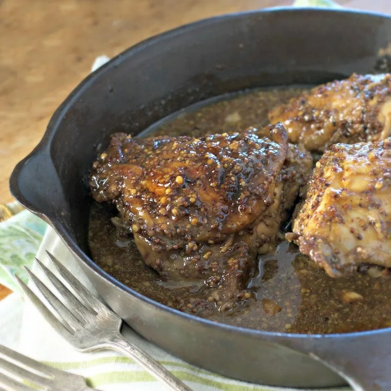 marinated chicken in a cast iron pan with forks